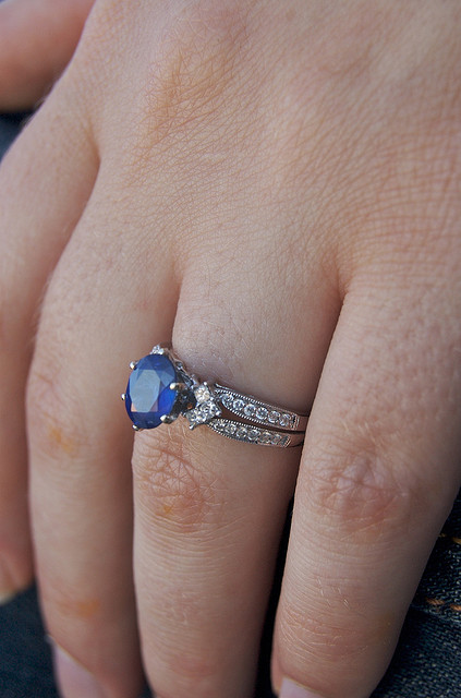 Close-up photo of Elisabeth's hand with a sapphire engagement ring